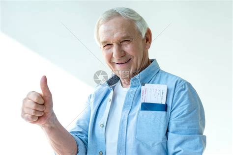 喜悦的老人肖像护照和机票显示大拇指起高清图片下载-正版图片502693960-摄图网