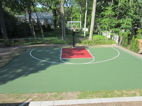 This is a forest green and red concrete backyard basketball court we ...