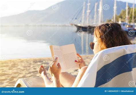 Reading on the beach stock image. Image of lifestyles - 148044559