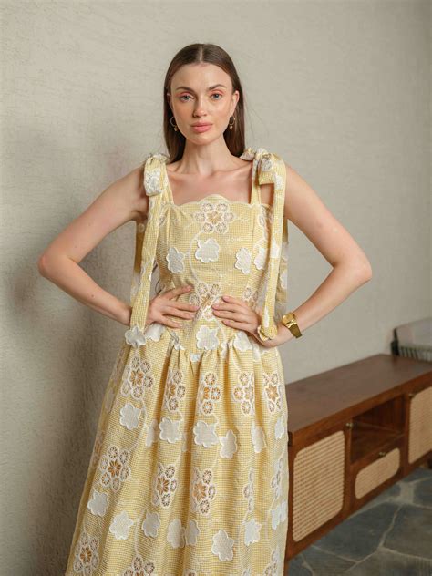 BREZELLA – A cutwork drop-waist dress featuring tie-up straps at the s ...