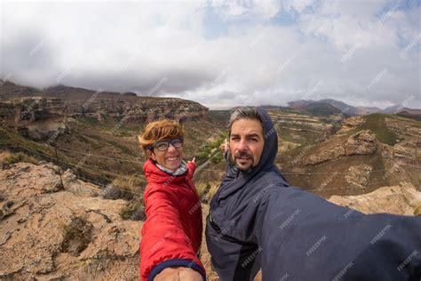 Couple selfie with outstretched arms, wind mountain summit | Premium Photo