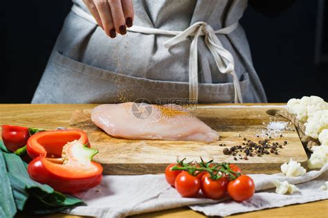 厨师在木切削板上的鸡胸上洒辣椒粉背高清图片下载-正版图片505790557-摄图网