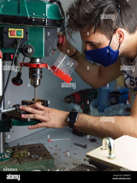 Vertical shot of a Spanish Caucasian man wearing a facemask, working in ...