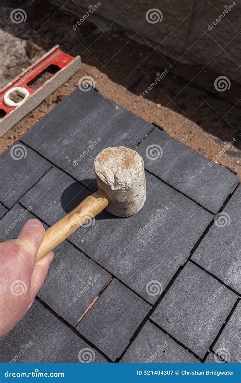 Man Laying Composite Decking Tile Patio with a Rubber Mallet. Stock ...