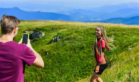 年轻的冒险家夫妇拍照热恋中的情侣徒步登山让我们拍照捕捉美丽男人和女人摆出手机照片暑假概念和亲高清图片下载-正版图片506228499-摄图网