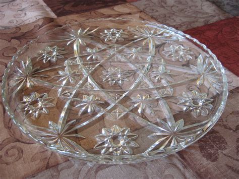 a clear glass plate sitting on top of a quilted tablecloth covered ...