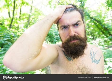 Sweating and body odor care. Perspiring hipster touching his wet hair. Bearded man experiencing ...