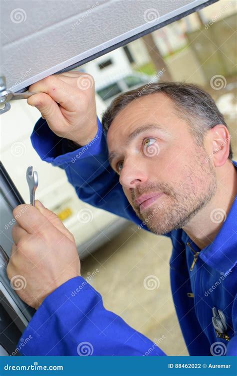 Man installing garage door stock photo. Image of installation - 88462022