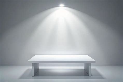 Blank white table with bright spotlight isolated on white wall empty ...