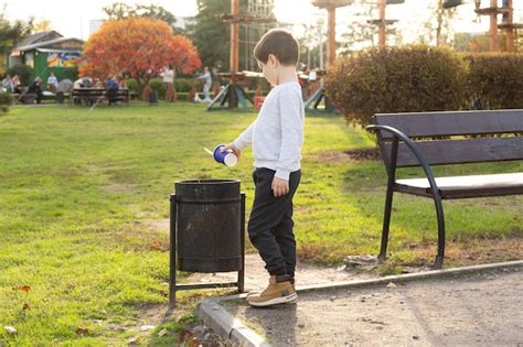 Ребенок бросает пластиковую чашку в мусор Концепция переработки мусора ...