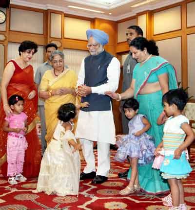 Prime Minister Manmohan Singh interacts with a handicapped child on the ...