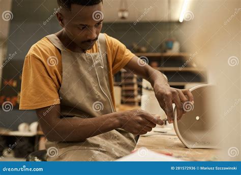 African Ceramist Making Holes In A Pot At A Workbench In A Studio Stock ...