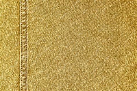 Yellow denim jeans with a seam texture background | Premium Photo