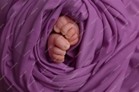 Premium Photo | Legs of a newborn baby baby's feet baby feet on purple ...