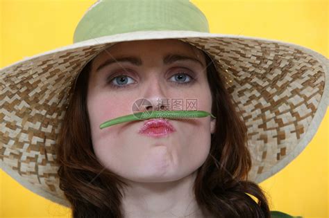 女人在嘴唇和鼻子之间平衡绿色豆子高清图片下载-正版图片306933403-摄图网