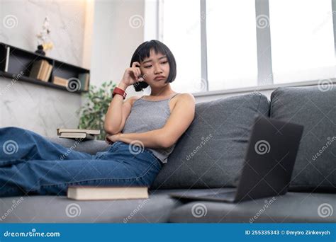 A Girl Sitting on the Sofa with a Laptop and Looking Busy Stock Image ...