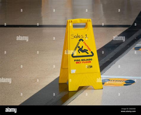 Yellow Wet Floor Warning Tool Written in English and Spanish at the ...