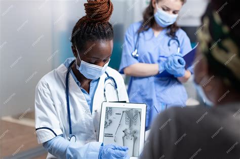 Premium Photo | Bone doctor explaining clinical information on tablet to patient during ...