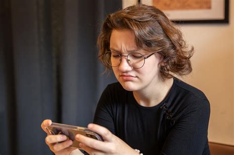 Sad teenage girl playing mobile games on phone emotion concept | Free Photo