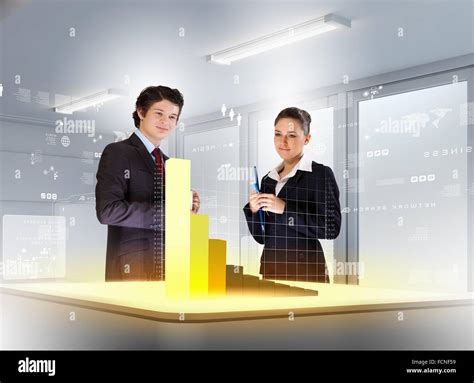 young businesspeople looking at graph of high-tech image Stock Photo ...