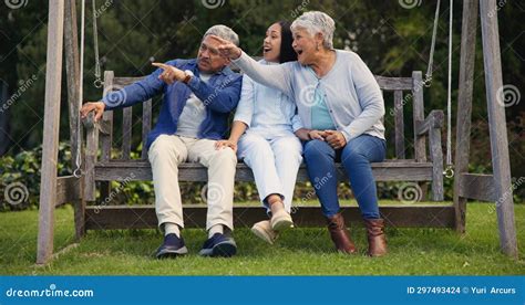 Adult daughter talking to her senior parents on a bench in a park