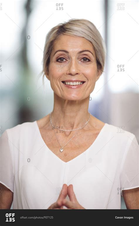 Portrait of beautiful 67 year old smiling woman stock photo - OFFSET