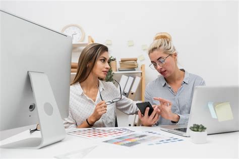Biznesowe kobiety patrzeje na telefonie | Darmowe zdjęcie