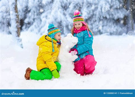 Kids Making Winter Snowman. Children Play in Snow Stock Image - Image ...