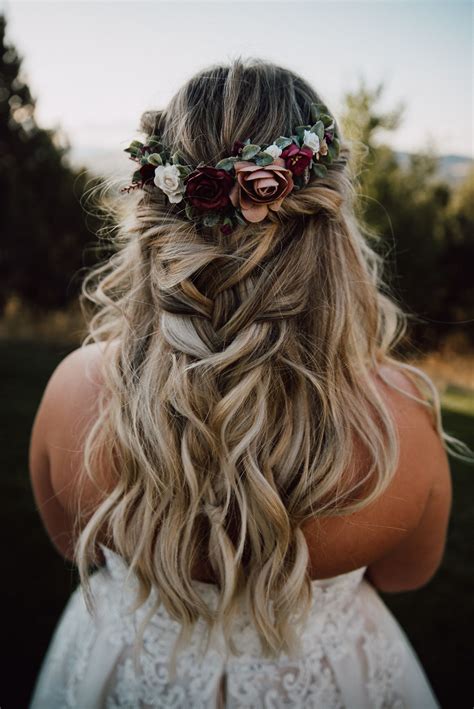 a woman with long blonde hair and flowers in her hair, wearing a flower ...