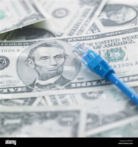 a pile of dollar bills under an internet cord Stock Photo - Alamy