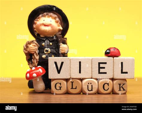 German words Good luck on wooden blocks and decoration on a yellow ...