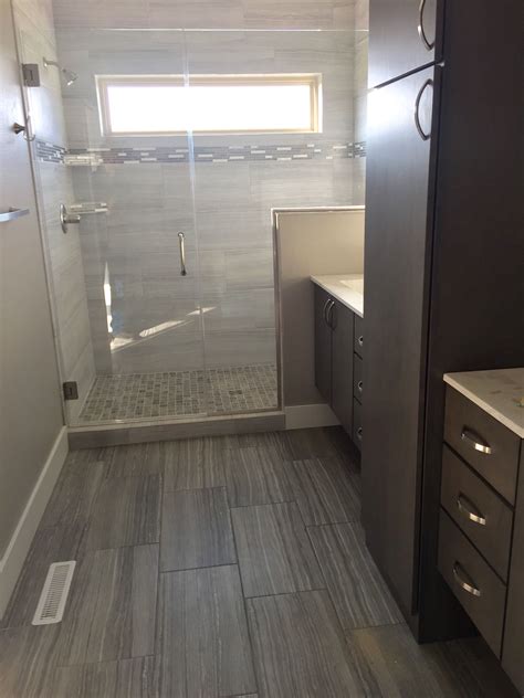 Dark gray 12x24 floor tile transitioning into a light white gray tiled ...