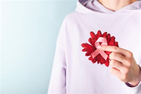 Różowa wstążka świadomości raka piersi Kobiece ręce trzymające czerwoną ...