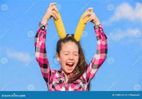 Vegetarian Nutrition Concept. Kid Girl Hold Yellow Corn Cob on Sky Background. Girl Cheerful ...