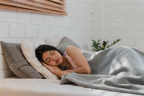 Asian Japanese woman sleep at home. Young Asian girl feeling happy relax rest lying on bed, feel ...