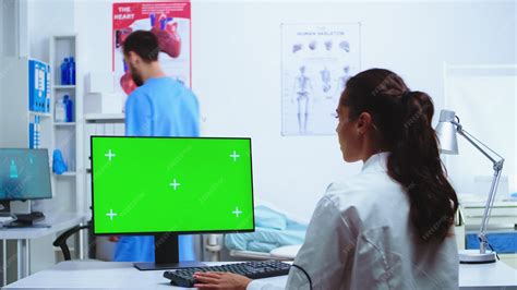 Doctor taking notes on computer with chroma key green screen and nurse ...