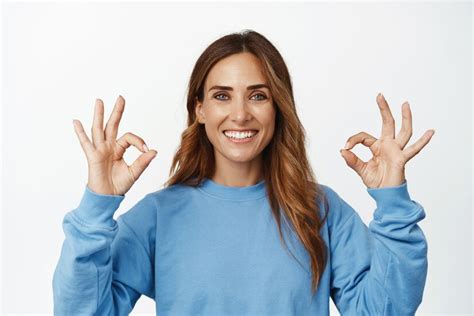 Portrait d'une femme brune souriante montrant ok, ok signe d ...