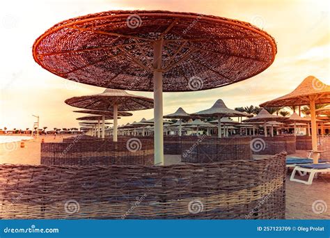 Straw Umbrella with Wind Fences in the Sunset. Beach Umbrellas, View of ...