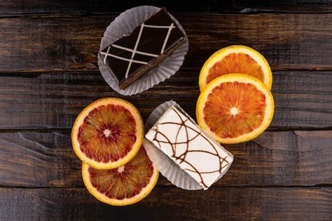 Two cakes of dark and white chocolate and slices of oranges, top view ...