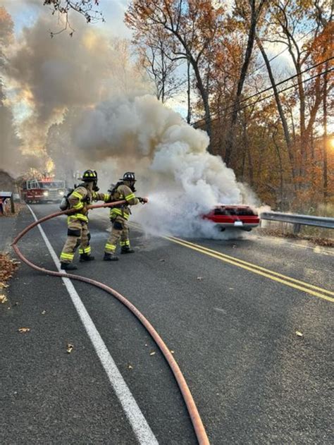 Southbury firefighters extinguish car fire, preventing brush fire risk