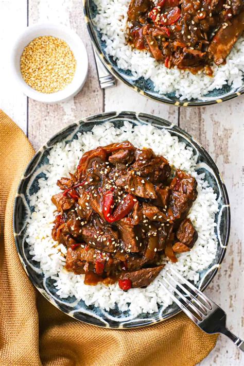 A bowl of slow cooker pepper steak, served over white rice