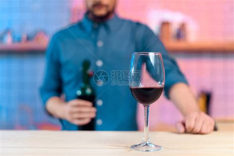在酒吧柜台拿着酒瓶和玻璃红酒和红酒的胡高清图片下载-正版图片502925702-摄图网