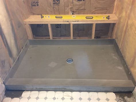 Solid shower pan being installed for new all marble tile shower ...