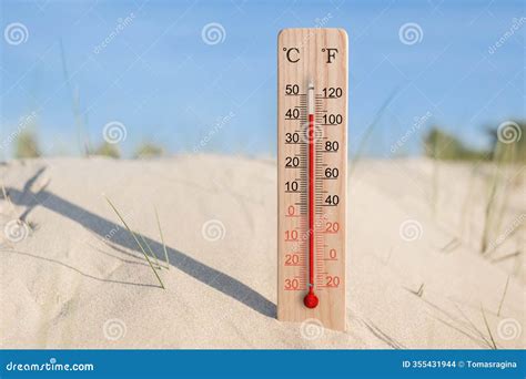 Wooden Celsius and Fahrenheit Scale Thermometer in the Sand. Ambient ...