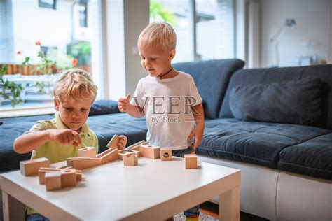 两个白人兄弟在家里玩木制玩具积木和弹珠照片摄影图片_ID:388841307-Veer图库