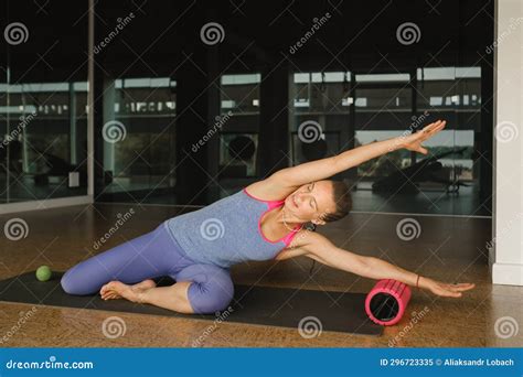 Slender Girl Doing Yoga with a Big Massage Roller on the Floor Stock ...