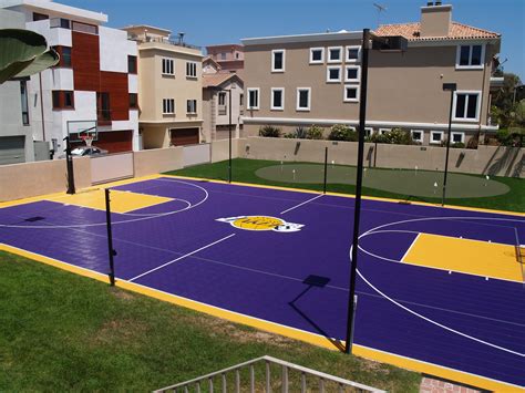 an outdoor basketball court is painted purple and yellow
