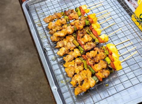 Barbecued skewers are grilled and placed on a stainless steel skewer ...