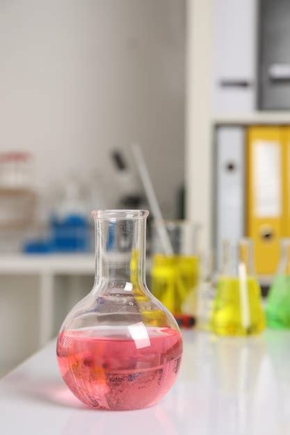 Laboratory analysis flask with pink liquid on white table | Premium Photo