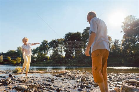 一对风趣的老夫妇在河边玩水高清图片下载-正版图片502637875-摄图网